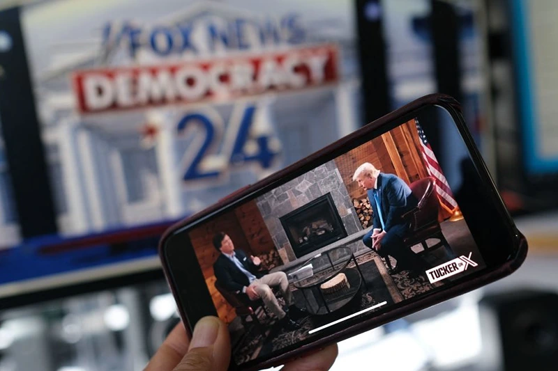 TOPSHOT - This illustration photo shows a preview of Tucker Carlson's interview of former US President Donald Trump scheduled to air on X (formerly Twitter) on the same night of the first Republican Presidential primary debate in Milwaukee, Wisconsin, on a smartphone ahead of the debate on August 23, 2023. (Photo by Chris DELMAS / AFP) (Photo by CHRIS DELMAS/AFP via Getty Images)